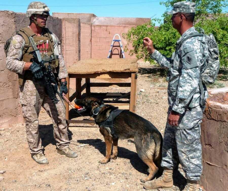 Marine serving in the military police takes a serious photo next to a police car